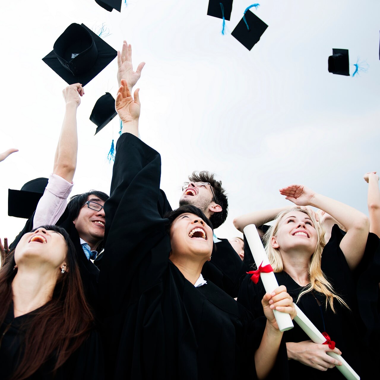 group-diverse-grads-throwing-caps-up-sky (1)